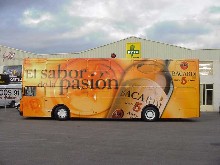 Autobús naranja estacionado con publicidad de autobuses Bacardi.