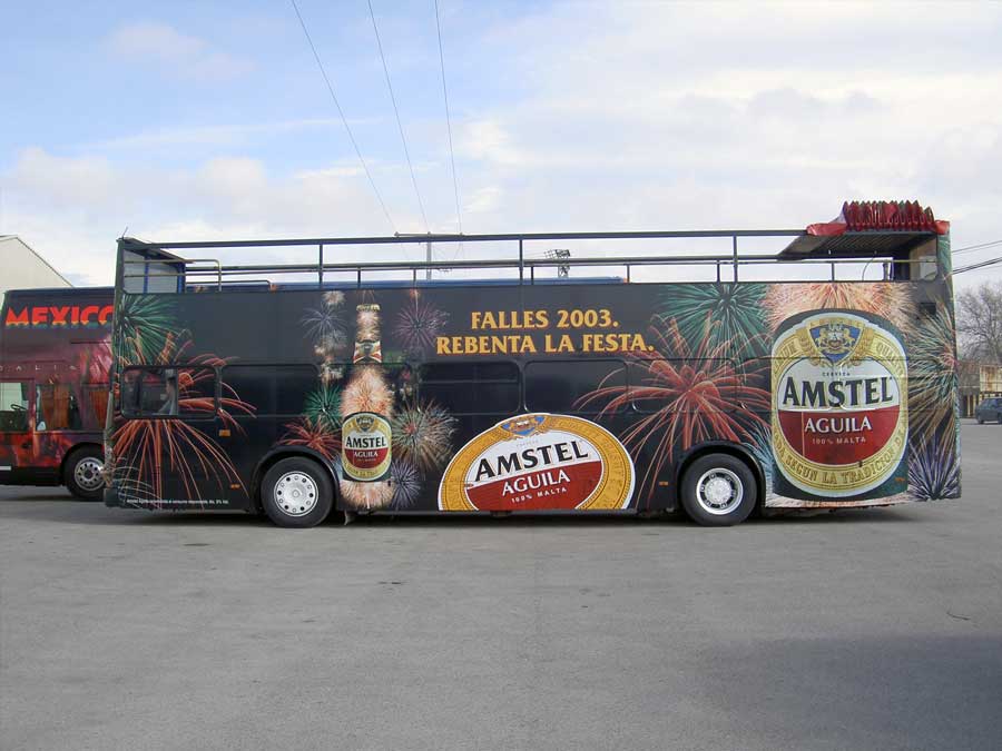 Autobús negro estacionado con una publicidad en autobuses Amstel.