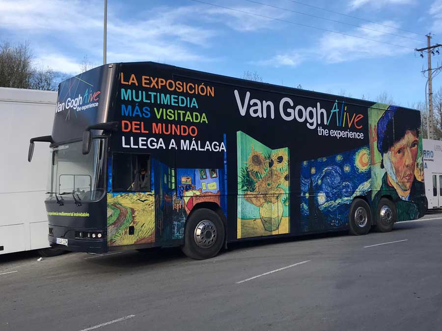 Autobús negro estacionado con publicidad de roadshow Van Gogh.